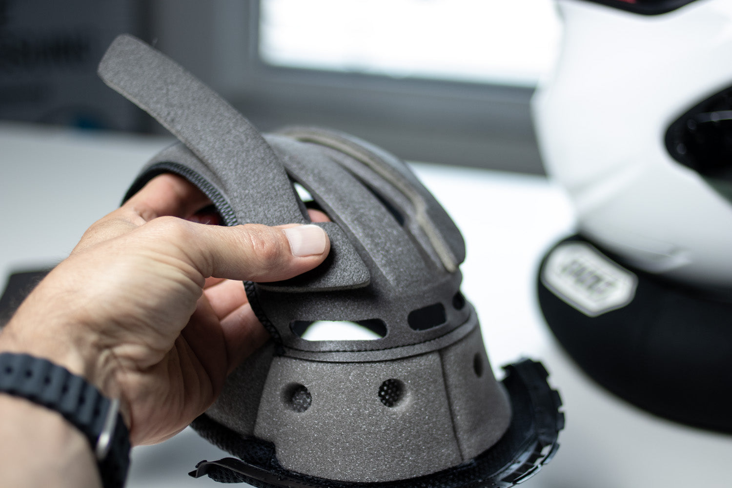 SHOEI technician adjusting helmet padding during PFS fitting